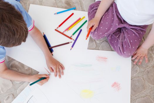 brother and sister drawing pictures with coloring pencils