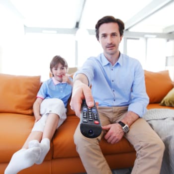 father and son watching tv inside their house