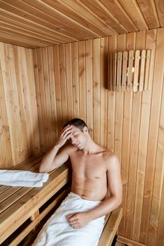 Serious man resting in the sauna