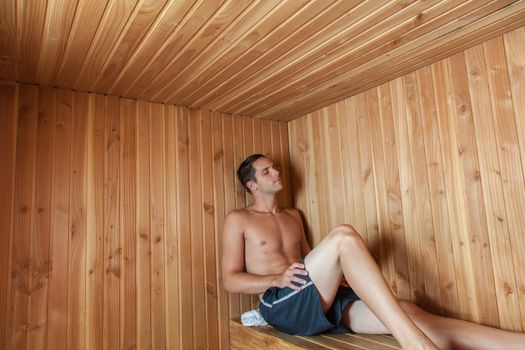 Serious man sit inside the sauna