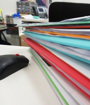 Stack of many color document folder on desk at office.                               