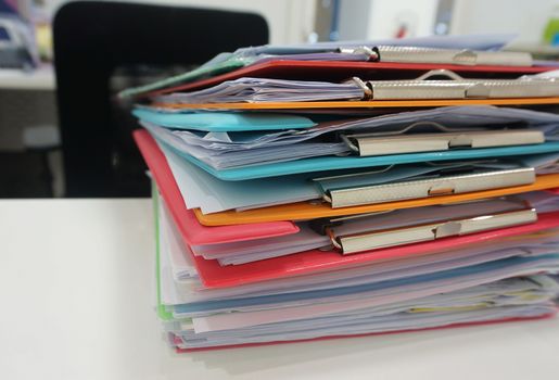 Stack of many color document folder on desk at office.                                