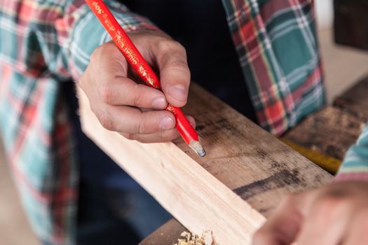 Guy marking wood with a pencil