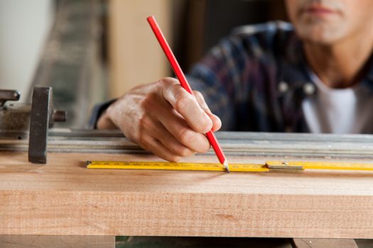 Serious carpenter marking a plank