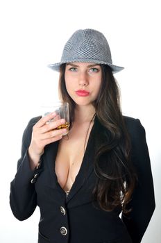 Girl holds glass with drink. Young female model puts dark tail-coat and classic hat.