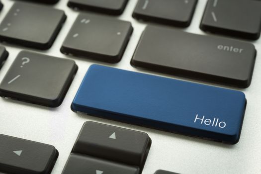 Close up computer keyboard focus on a blue button with typographic word HELLO search engine optimization and computer sign. Language and social media concepts.