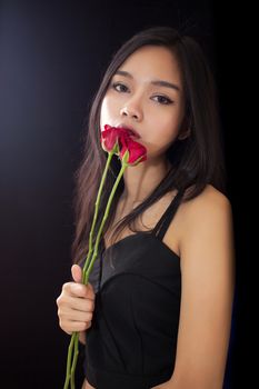 Beautiful asian women and red rose on black background .