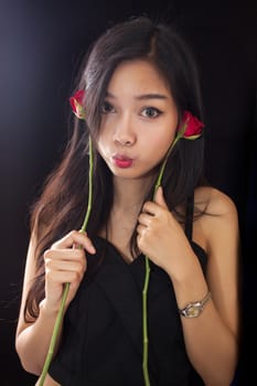 Beautiful asian women and red rose on black background .