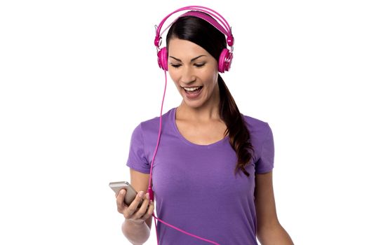 Cheerful woman listening music on her cell phone