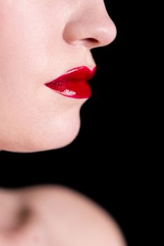 Close-up shot of woman lips with glossy red lipstick