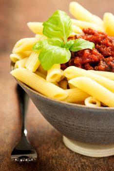 Penne pasta with a tomato bolognese beef sauce on the table