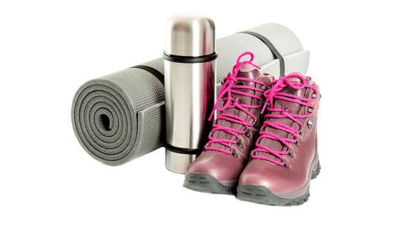 Hiker equipment: pair of mountain boots, thermo flask and sleeping mat on white background