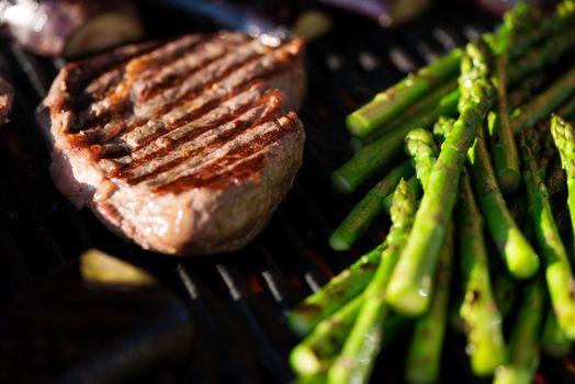 Steak and vegetables on grill at sunset, candid