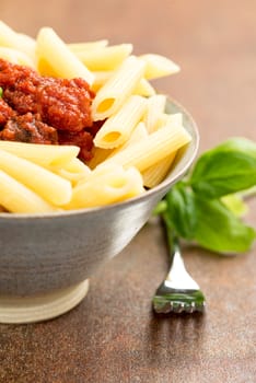 Penne pasta with a tomato bolognese beef sauce on the table