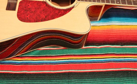Traditional Mexican fiesta poncho rug  in bright colors with sombrero background with copy space