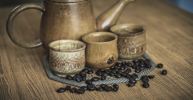 Vintage photo of coffee beans and Coffee cups set on wooden background.Vintage style.