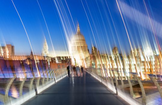 Blurred image of people moving along Millennium Bridge, London.