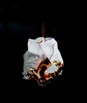 white crumpled  paper burning on black background