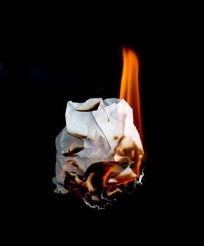 white crumpled  paper burning on black background