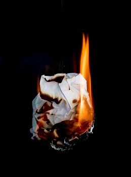 white crumpled  paper burning on black background