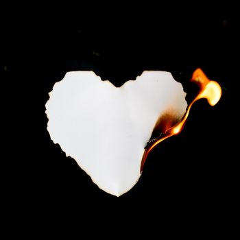 heart shape paper burning on black background