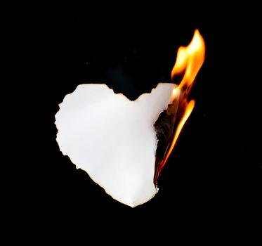 heart shape paper burning on black background