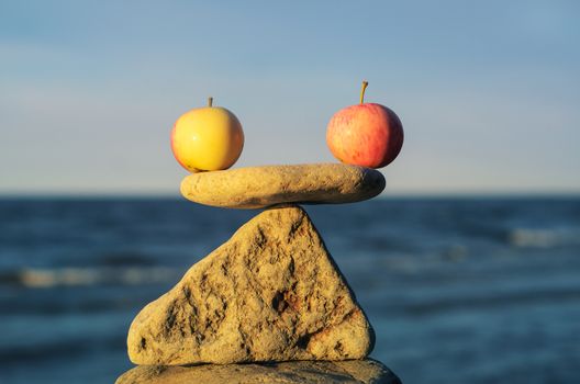 Two apples in balance on the top of stone