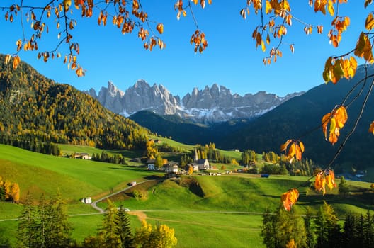 The mountain village and church of St. Magdalena (Santa Maddalena) in the Villnösstal (Val di Funes) in South Tyrol in Italy with in the background the Geisler (Odle) dolomites mountain group.