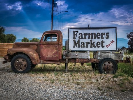 Sign For A Farmers Market On The Side Of A Vintage Rusty Truck