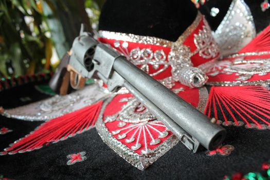 sequin and decorative ornate mexican hat ready for a fiesta with a gun