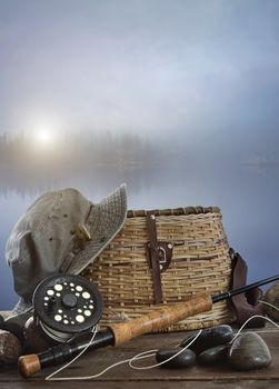 Fly rod with creel and equipment on wood table