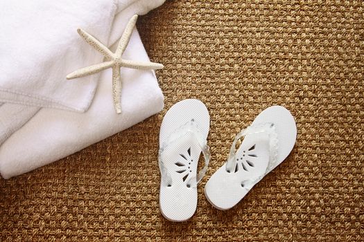 Spa sandals on seagrass mat with towels