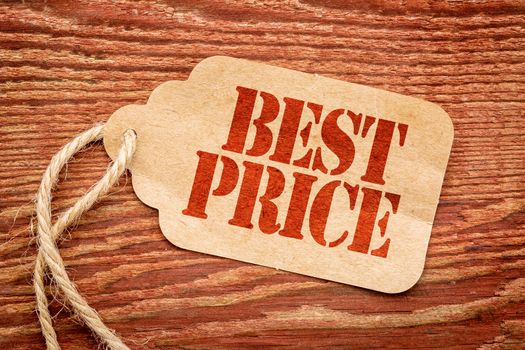 best price sign a paper price tag against rustic red painted barn wood - marketing concept
