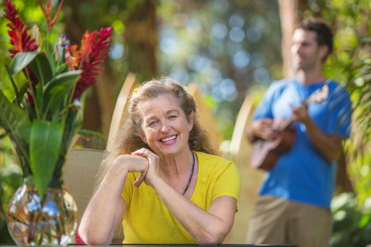 Grinning adult female listening to musician in Hawaii