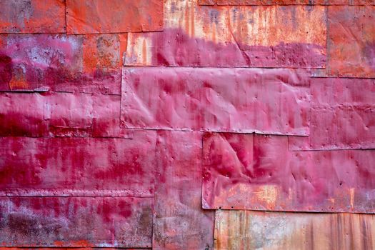 rusty red painted metal background texture - metal sheets covering a wall of an old industrial building