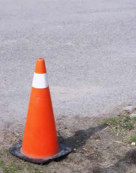 Caution cone on a road outside.            