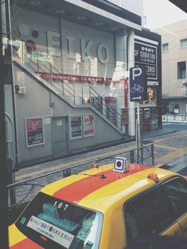 Tokyo, Japan - April, 13 2014: A japanese yellow taxi stopped in front of the zebra crossing.