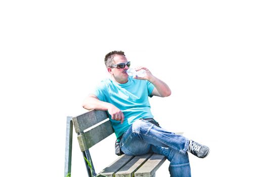 Man sitting on a bench drinking from a bottle of mineral water, isolated on white background.