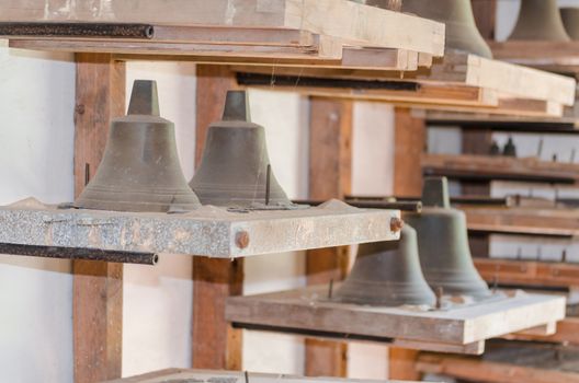 Bells of various sizes in the storage room of a disused small bell foundry.