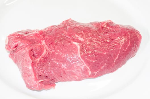 Fresh raw beef steak on a white plate.