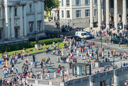 LONDON - JUNE 12, 2015: Tourists in Trafalgar Square. London attracts 50 million people annually.