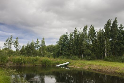 small lake with lonely boat in forrest