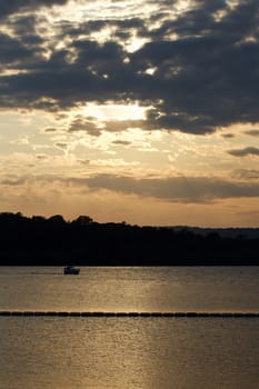 Beautiful sunset on the lake with the small ship