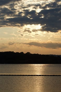 The sunset with the cloudy sky near the lake 