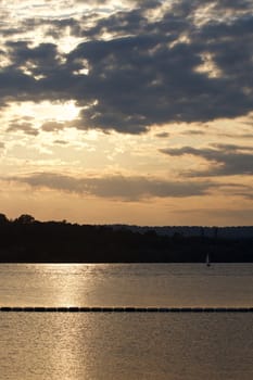 The sunset with the cloudy sky near the lake 