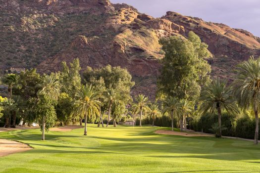 Golf course fairway bathed in beautiful golden hour light with Camelback Mountain in background, Phoenix,Az,USA