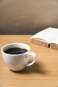 open book with coffee on wood background