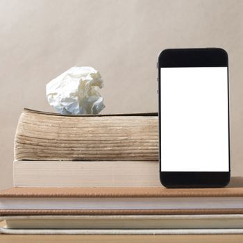 stack of book and smart phone on wood background