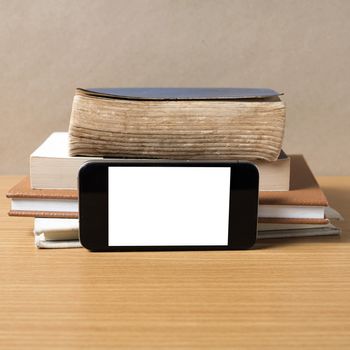 stack of book and smart phone on wood background