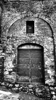 Wooden door with brick wall in Tuscany, Italy